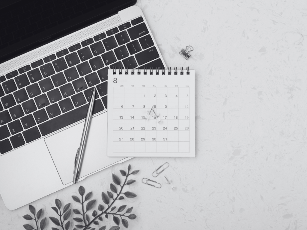  Ordenador portátil con un calendario pequeño y bolígrafo sobre escritorio, símbolo de planificación de contenidos digitales